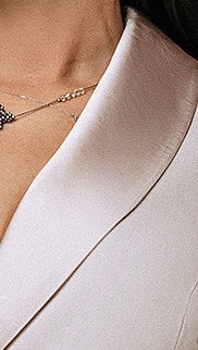 Close-up of silky satin shawl collar and gathered puff sleeve on custom beige dress